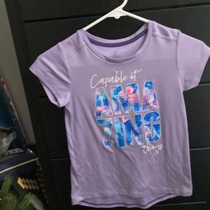 Purple shirt: text: capable of amazing things